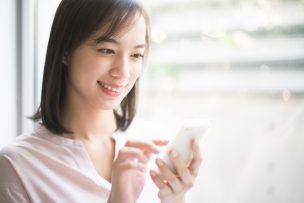WiFiにスマホを繋ぐ女性